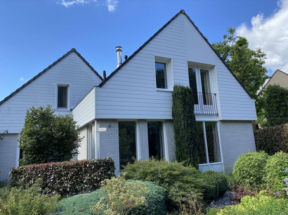 Wit geschilderde woning tegen een blauwe lucht