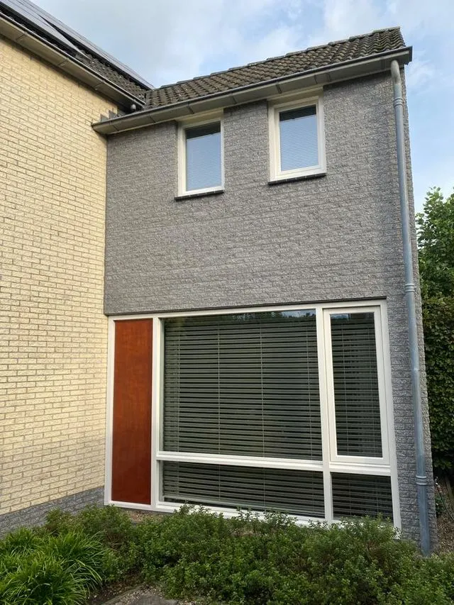 Grijs geschilderde gevel met witte kozijnen