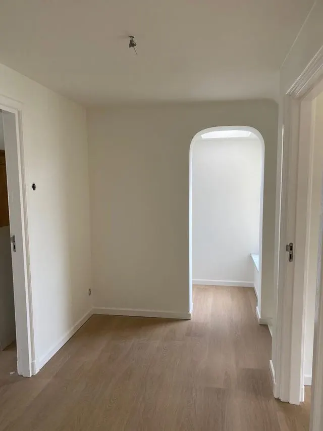 Vers geschilderde lichte binnenruimte met houten vloer
