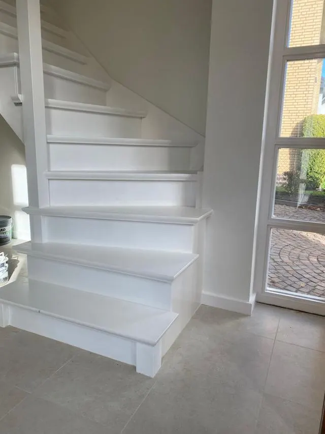 Wit geschilderde trap en muur in een woning