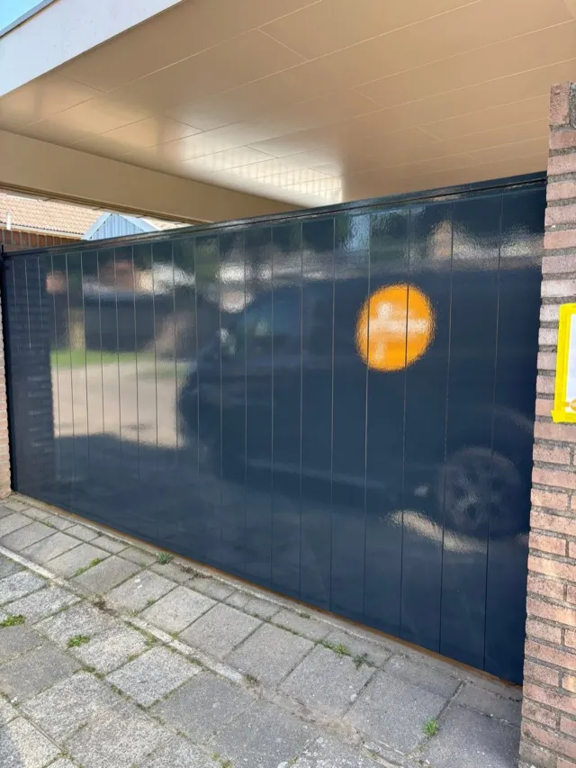 Donkerblauw geschilderde garagedeur met lichte overkapping