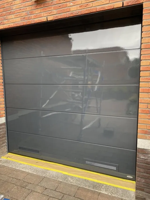 Glanzend donkergrijs geschilderde garagedeur