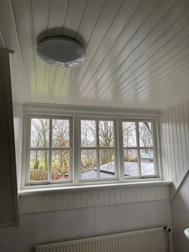 Wit geschilderd houten plafond en raamkozijnen