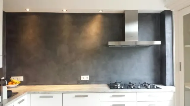 Donkere betonlook achterwand in een witte keuken