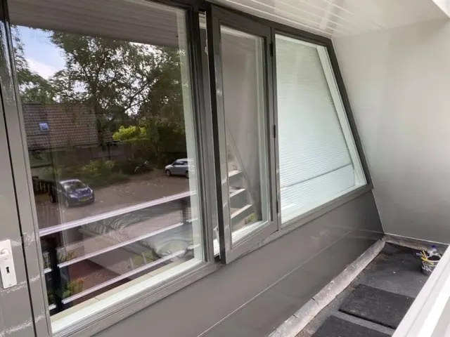 Glazen raamwand met draai-kiepramen op een verdieping